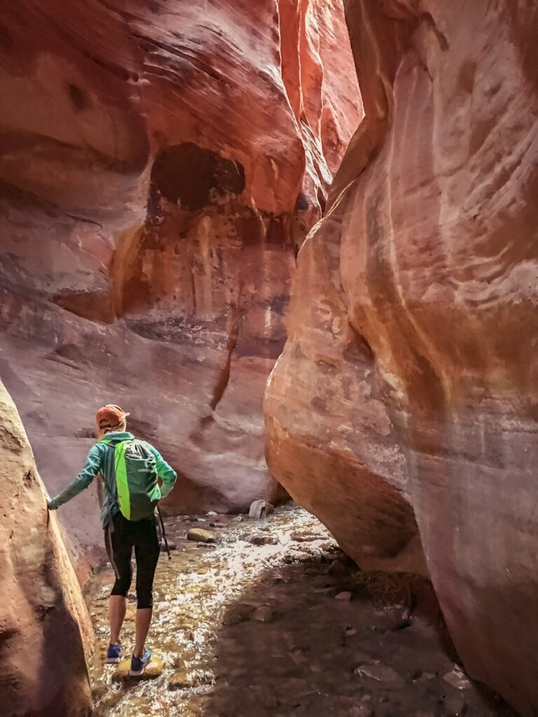 man in green jacket walking on brown rock formation during daytime